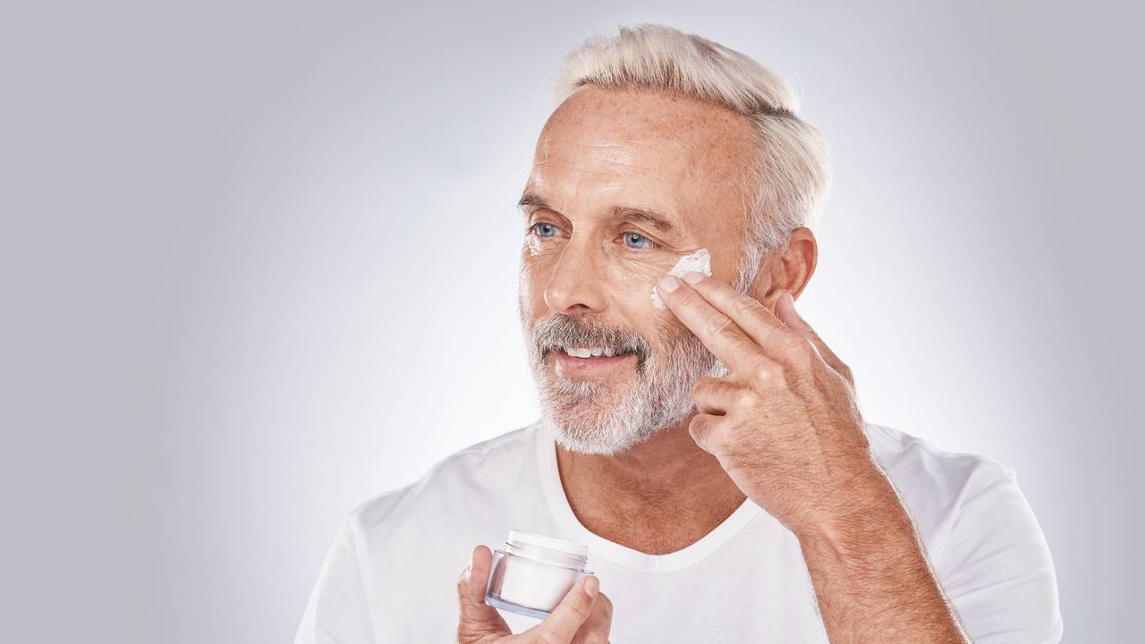 Ein Mann cremt sich das Gesicht ein
