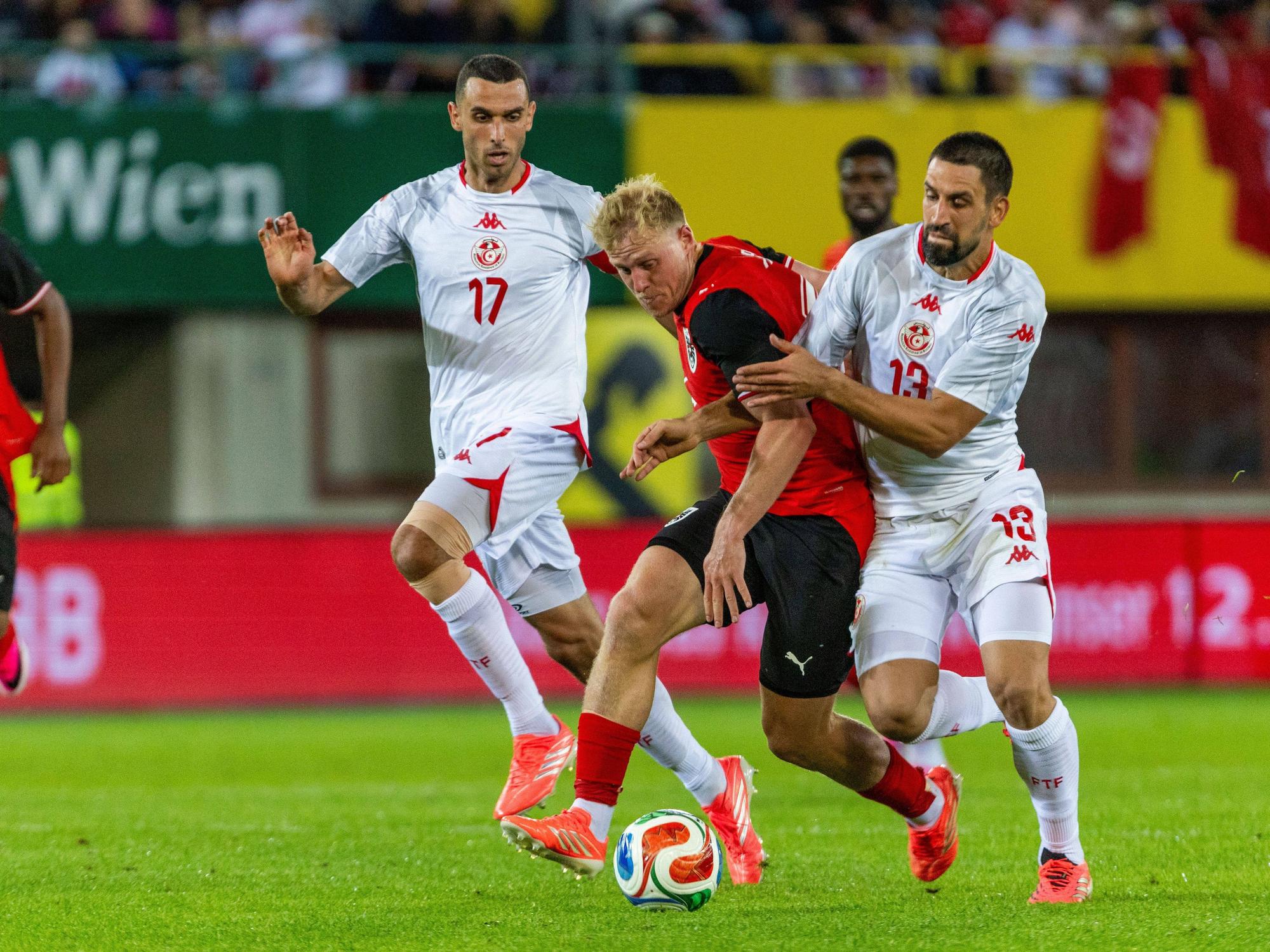 Rani Khedira im Zweikampf mit Xaver Schlager. Im Hintergrund kommt Ellyes Skhiri dazu.