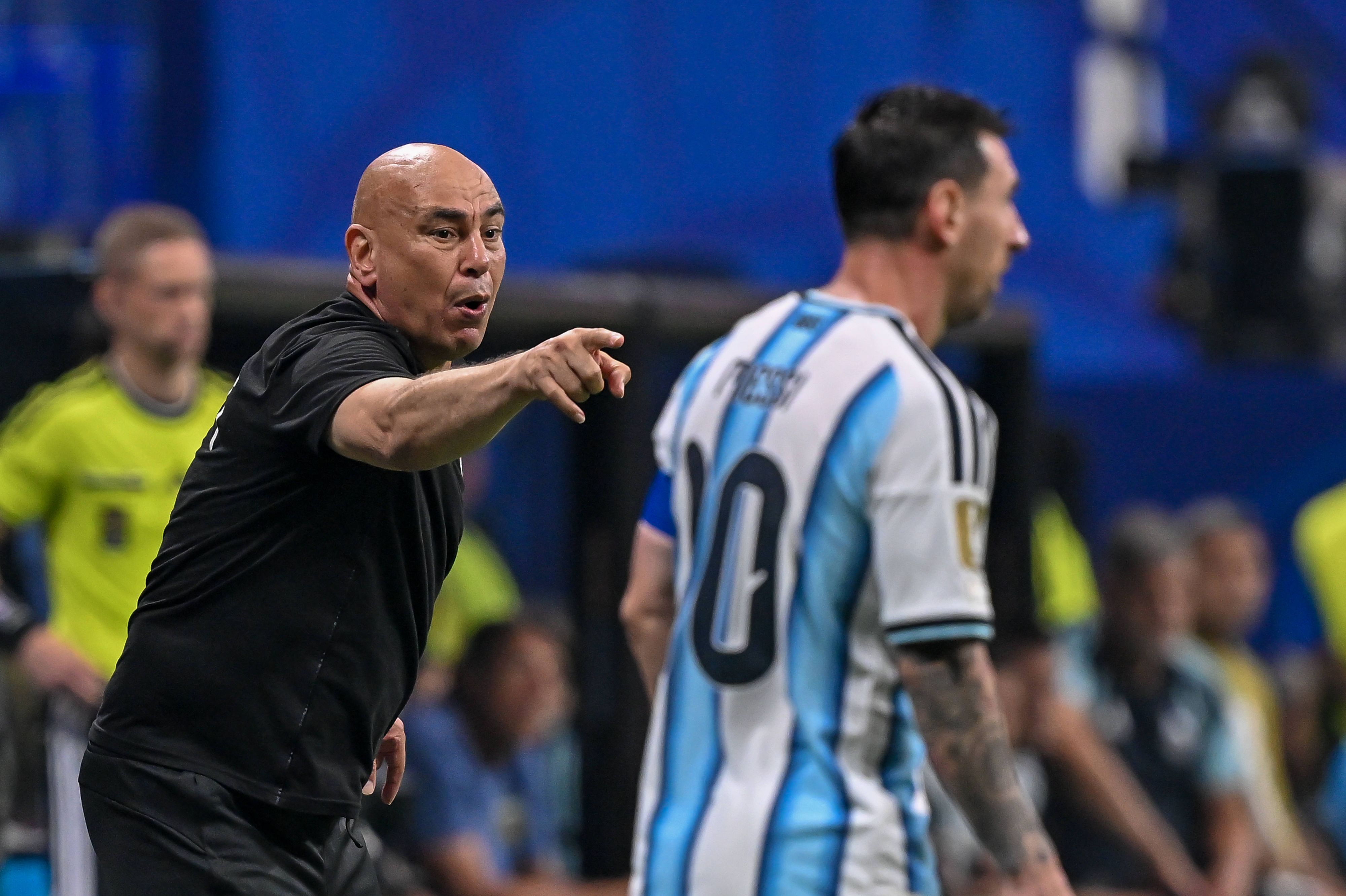 Hossam Hassan gestikuliert an der Seitenlinie. Im Vordergrund ist Lionel Messi unscharf zu sehen.