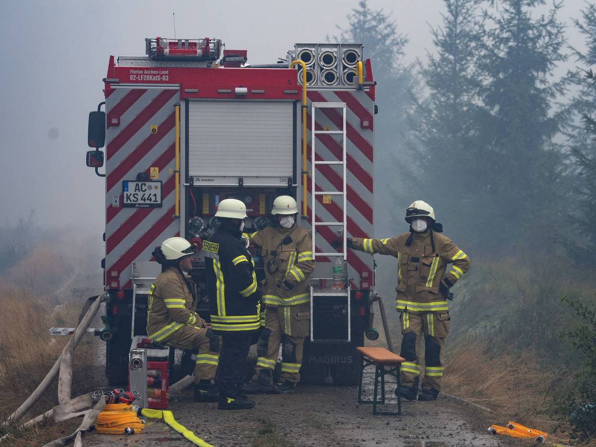 Einsatzkräfte der Feuerwehr aus dem deutschen Monschau sind im Waldgebiet im Einsatz.