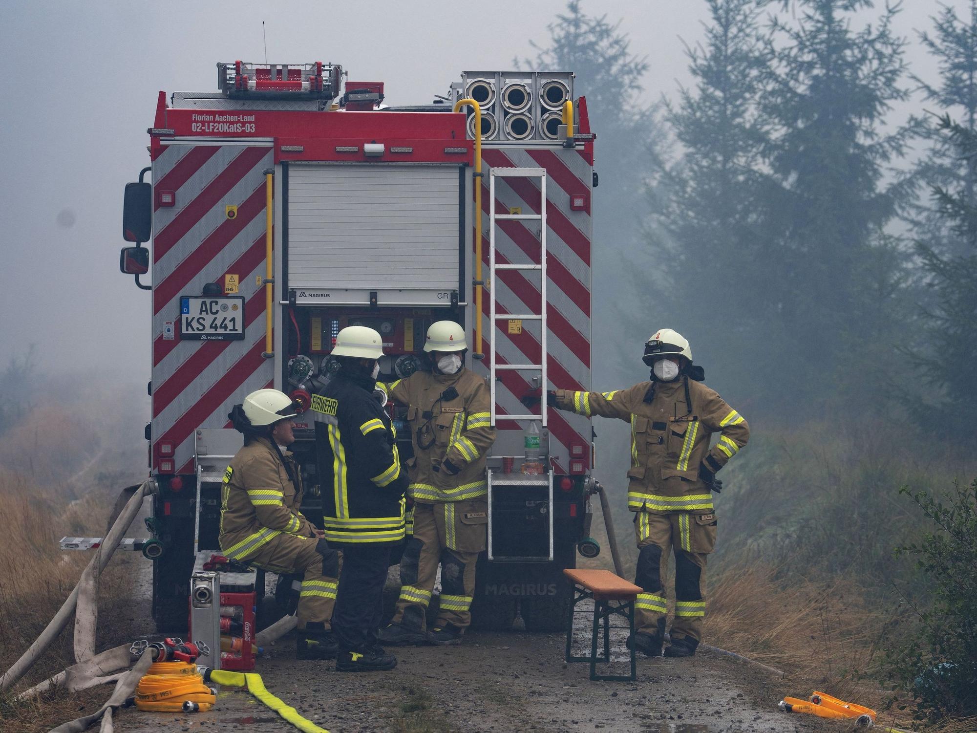 Einsatzkräfte der Feuerwehr aus dem deutschen Monschau sind im Waldgebiet im Einsatz.