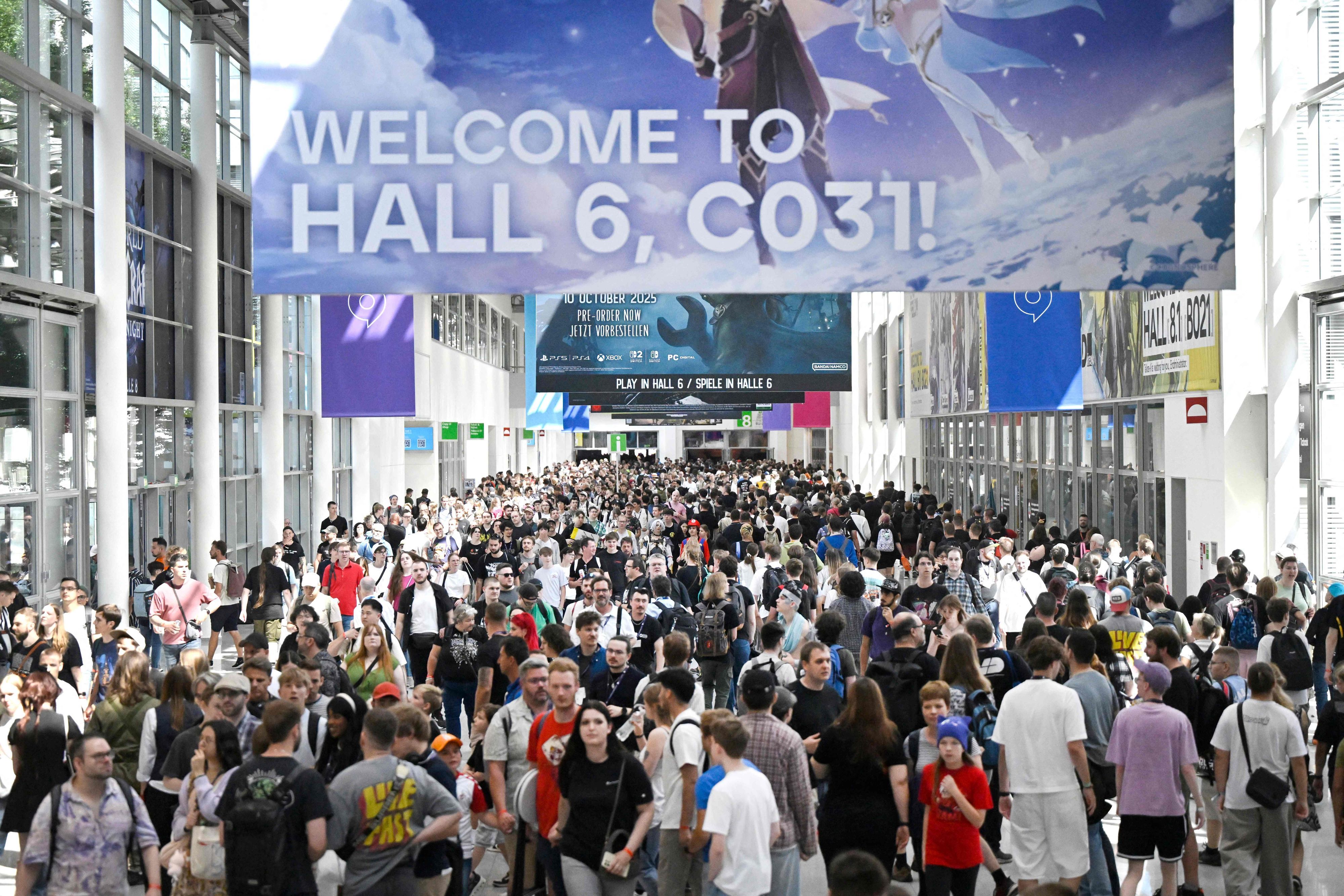Besucher der Gamescom gehen durch die Messehallen.