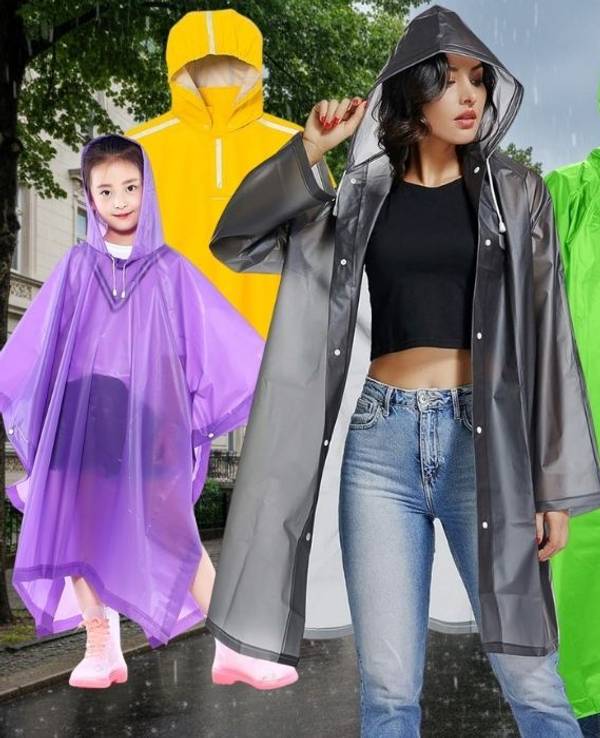 Regencapes und Regenponchos in verschiedenen Farben. Im Hintergrund eine Innenstadt mit verregnetem, grauem Himmel und nasser Fahrbahn