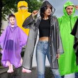 Regencapes und Regenponchos in verschiedenen Farben. Im Hintergrund eine Innenstadt mit verregnetem, grauem Himmel und nasser Fahrbahn