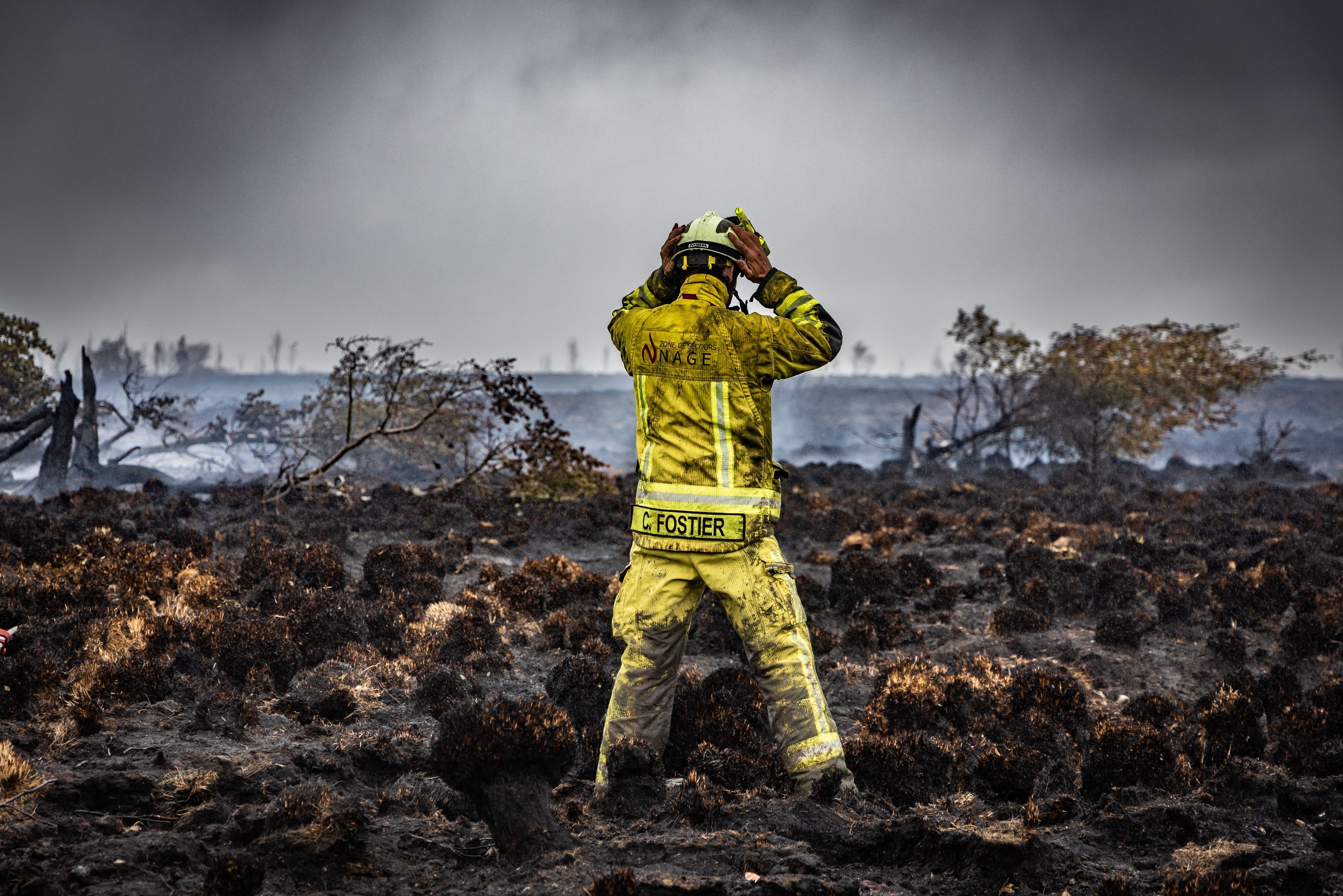 Ein Feuerwehrmann steht am Brandort im Naturschutzgebiet Hohes Venn. Die Bekämpfung des Waldbrandes ist wegen des torfhaltigen Bodens in dem Naturschutzgebiet besonders schwierig.
