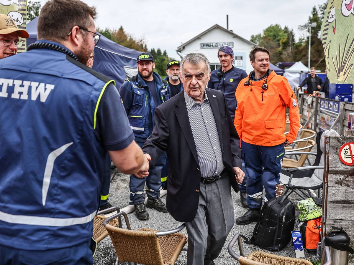 NRW-Innenminister Herbert Reul (Mitte, CDU) spricht mit Helfern des THW an der deutsch-belgischen Grenze an einer Wassertankstation.