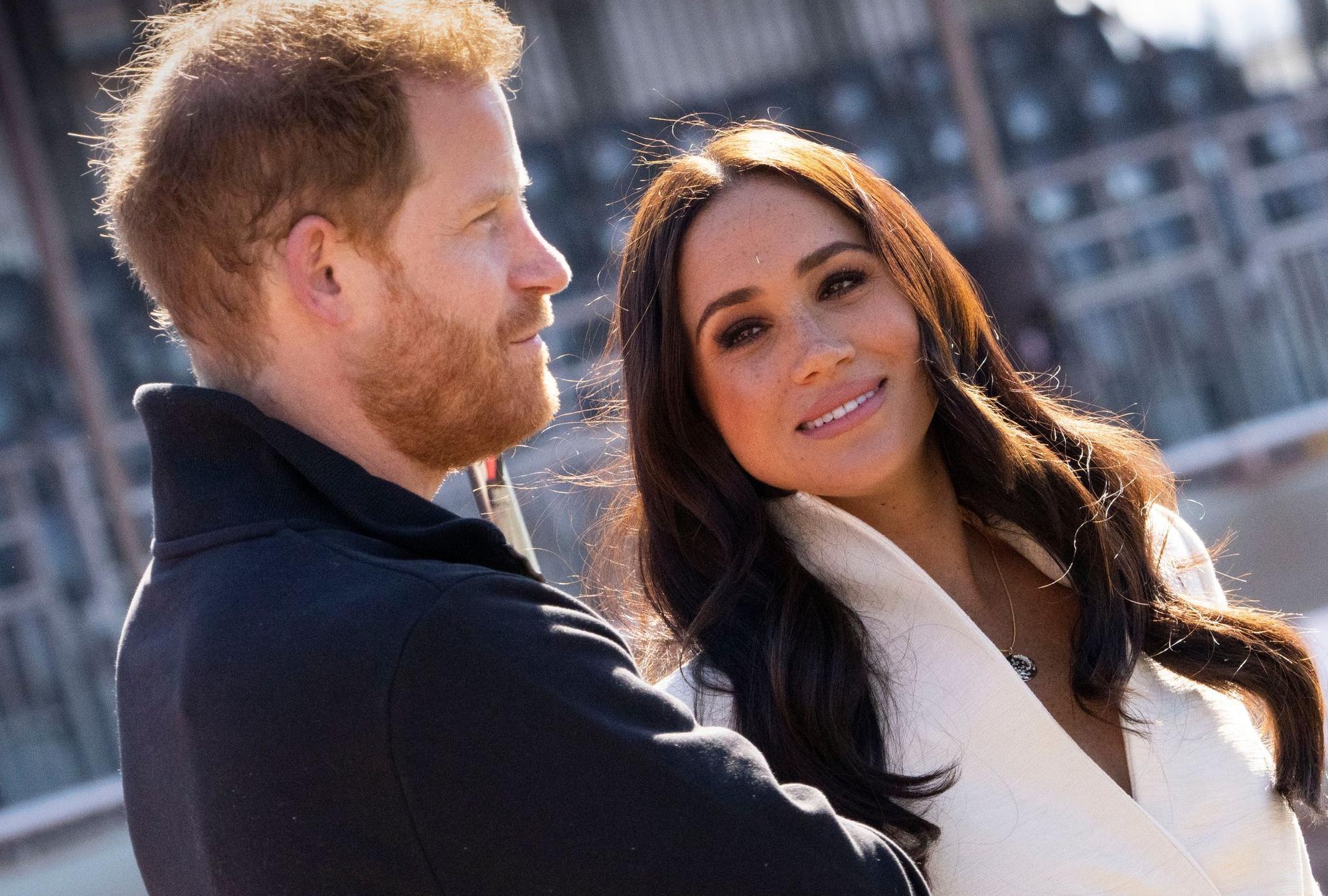 Prinz Harry und Meghan posieren nebeneinander.