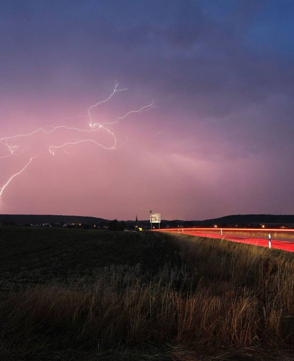 Blitze zucken bei einem abendlichen Gewitter über Mittelfranken.