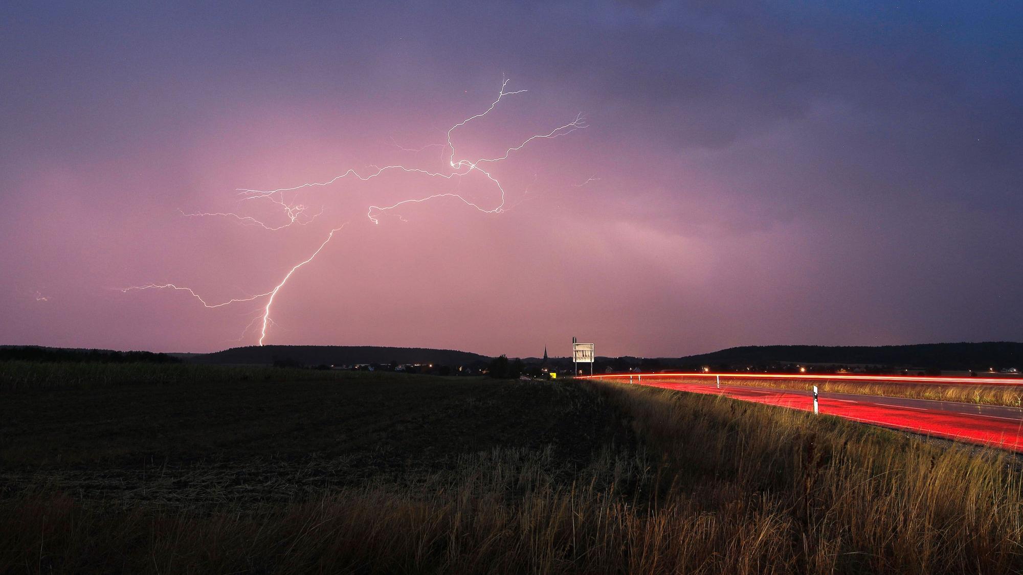 Blitze zucken bei einem abendlichen Gewitter über Mittelfranken.