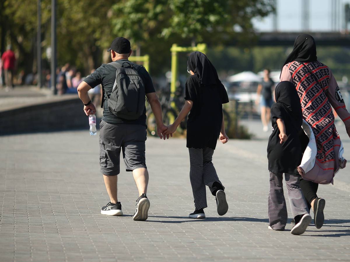 Eine vierköpfige Familie geht am Kölner Rheinufer entlang: Junge Familien zahlen laut einer neuen Erhebung in Köln am meisten für den Alltag.