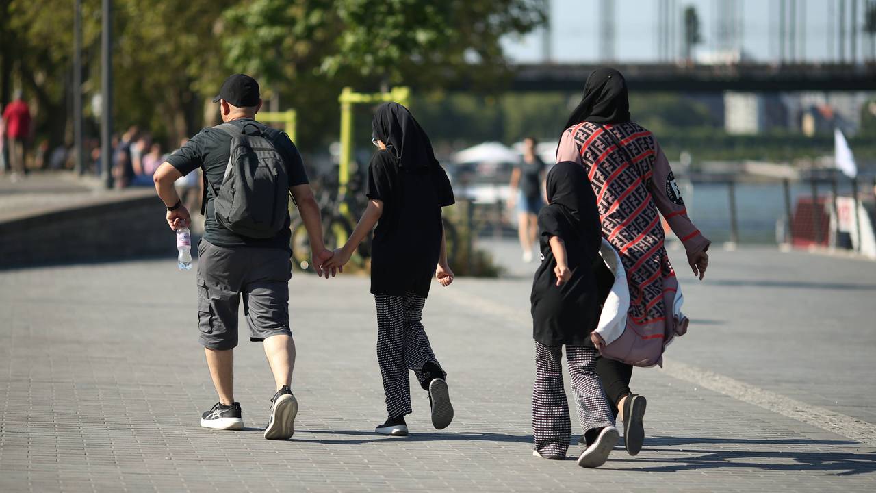 Eine vierköpfige Familie geht am Kölner Rheinufer entlang: Junge Familien zahlen laut einer neuen Erhebung in Köln am meisten für den Alltag.