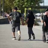 Eine vierköpfige Familie geht am Kölner Rheinufer entlang: Junge Familien zahlen laut einer neuen Erhebung in Köln am meisten für den Alltag.