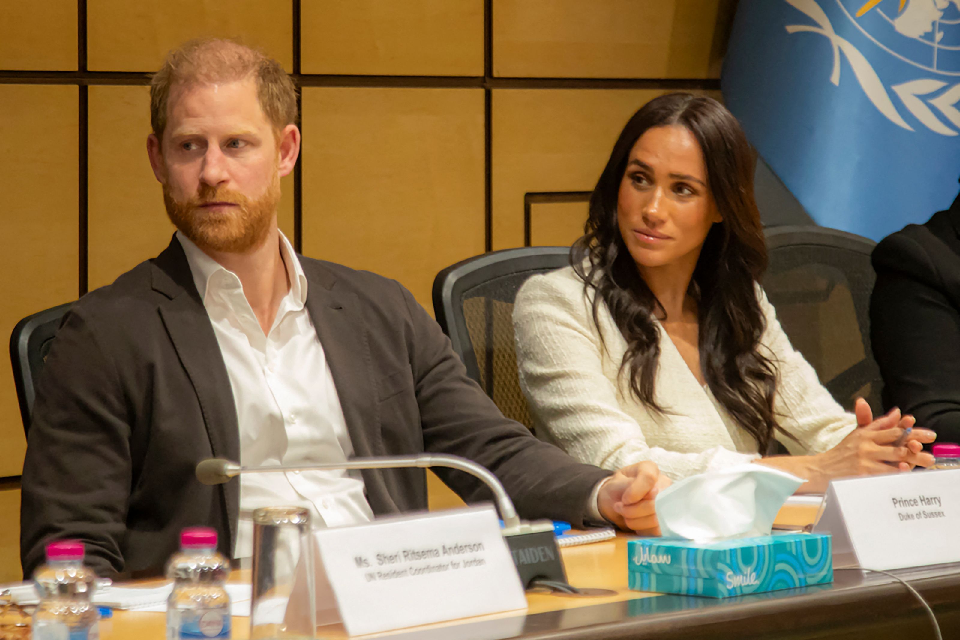 Harry und Meghan sitzen nebeneinander.