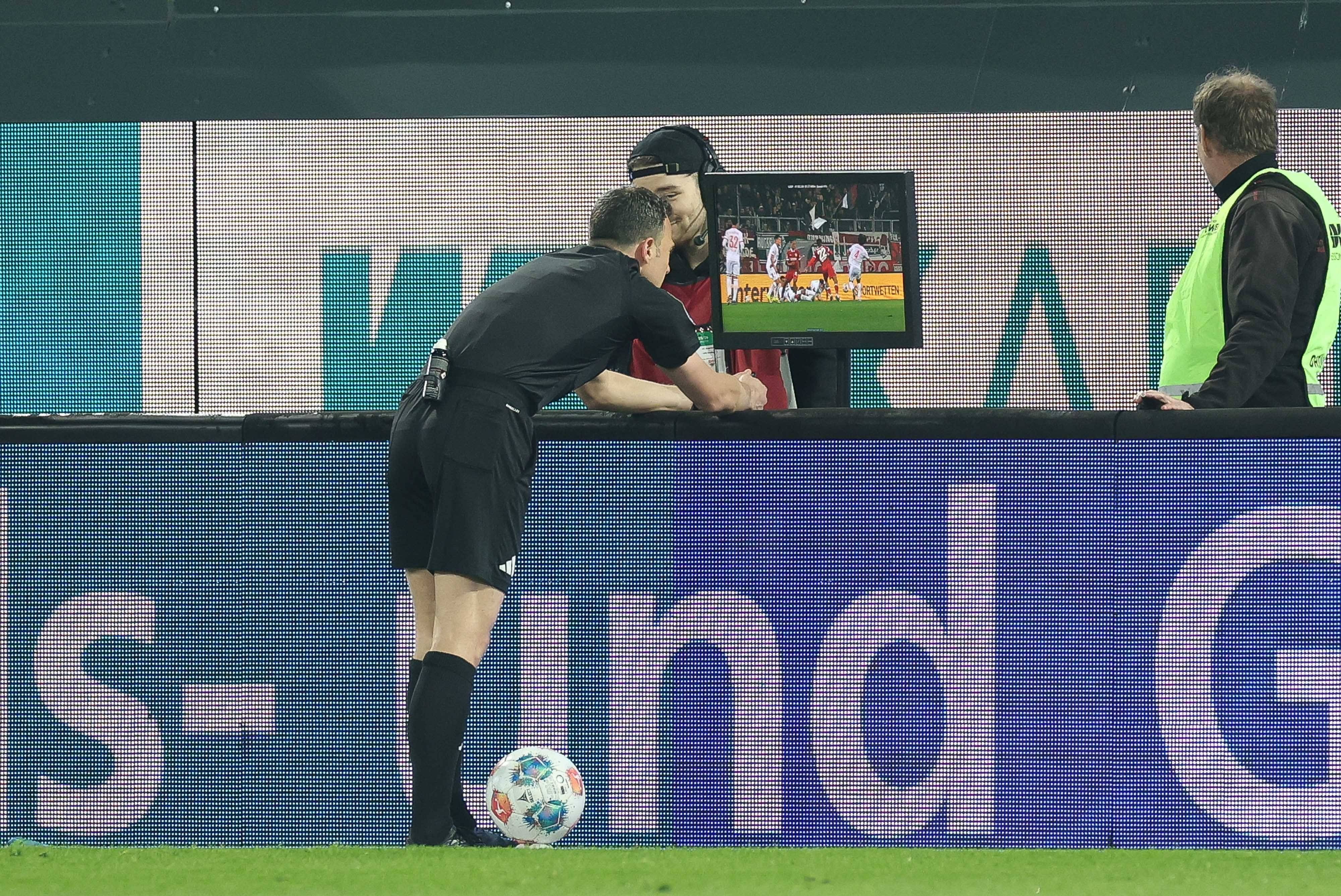 Schiedsrichter Felix Zwayer guckt bei einem VAR-Check auf den Bildschirm.