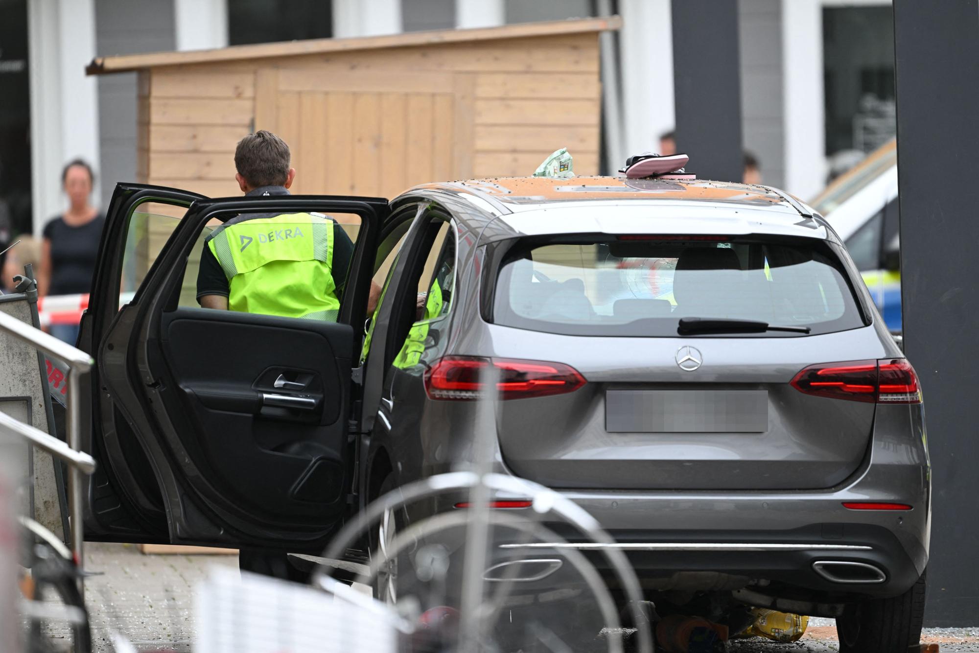 Mitarbeiter der DEKRA inspizieren ein beschädigtes Auto an der Unfallstelle. Ein Autofahrer raste am Vormittag mit hoher Geschwindigkeit durch die Fußgängerzone und verletzte dabei mehrere Menschen.