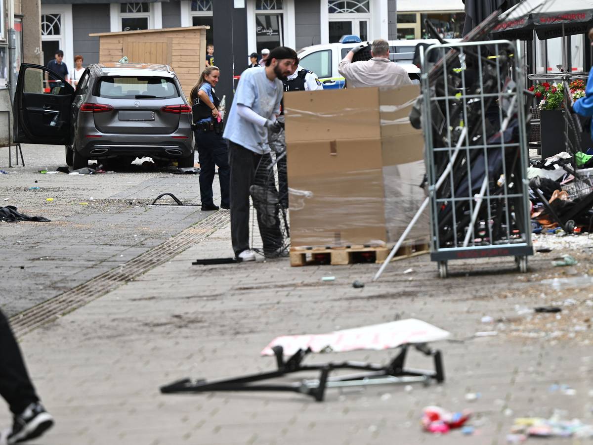 Mitarbeiter eines Geschäfts reinigen die Unfallstelle vor dem Laden. Ein Autofahrer raste am Vormittag mit hoher Geschwindigkeit durch die Fußgängerzone und verletzte dabei mehrere Menschen. Ursache war ersten Erkenntnissen zufolge ein medizinischer Notfall.