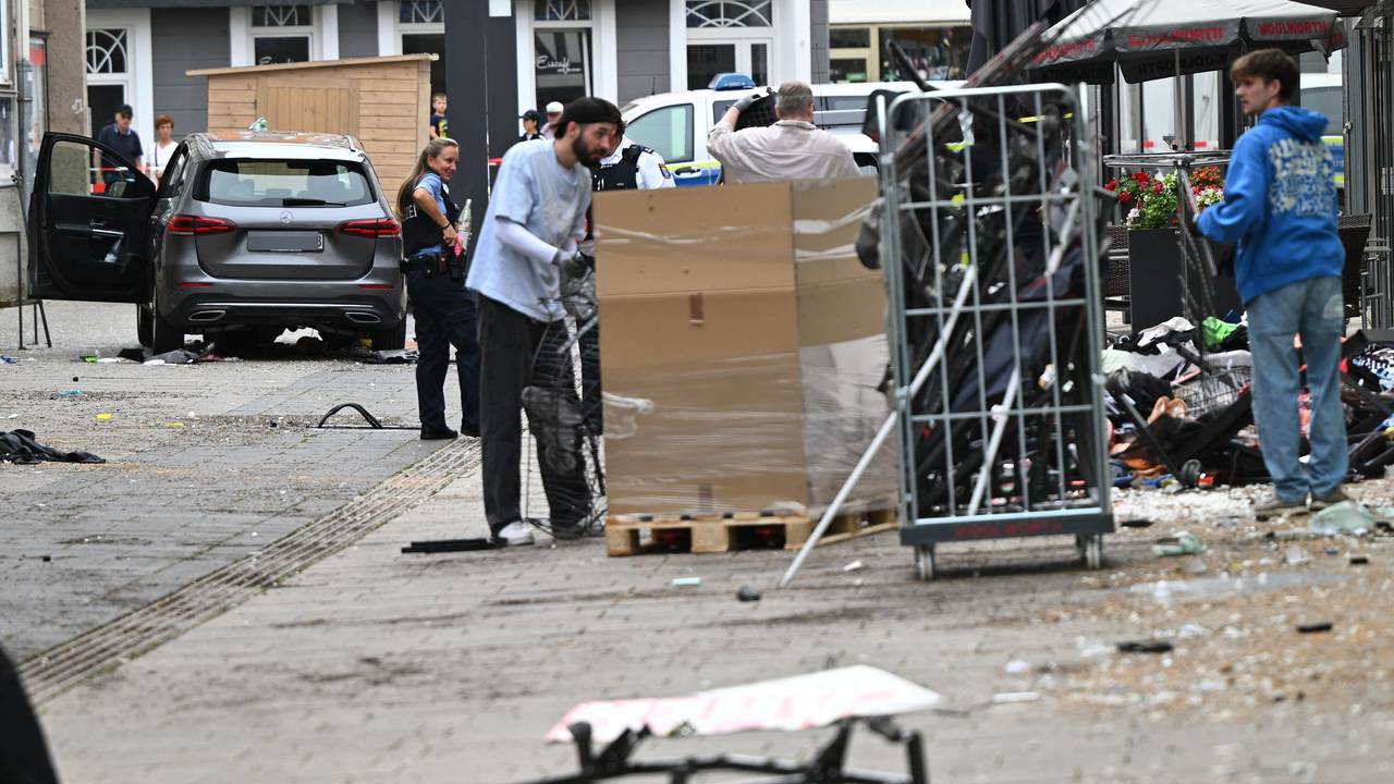 Mitarbeiter eines Geschäfts reinigen die Unfallstelle vor dem Laden. Ein Autofahrer raste am Vormittag mit hoher Geschwindigkeit durch die Fußgängerzone und verletzte dabei mehrere Menschen. Ursache war ersten Erkenntnissen zufolge ein medizinischer Notfall.