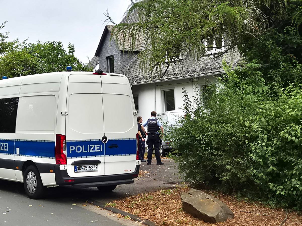 Einsatzkräfte der Polizei stehen vor einem Wohnhaus in Siegen. Die Polizei hat in einer Wohnung die stark verwesten Leichen einer 77-jährigen Frau und eines 55-jährigen Mannes entdeckt.