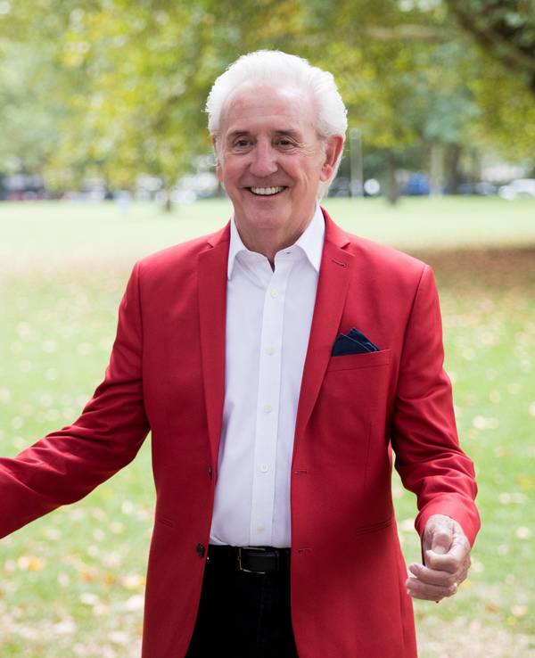 Schlagersänger Tony Christie steht bei einem Medientermin vor dem Hotel.