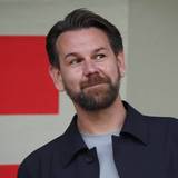 Thomas Kessler beobachtet lächelnd ein Testspiel.