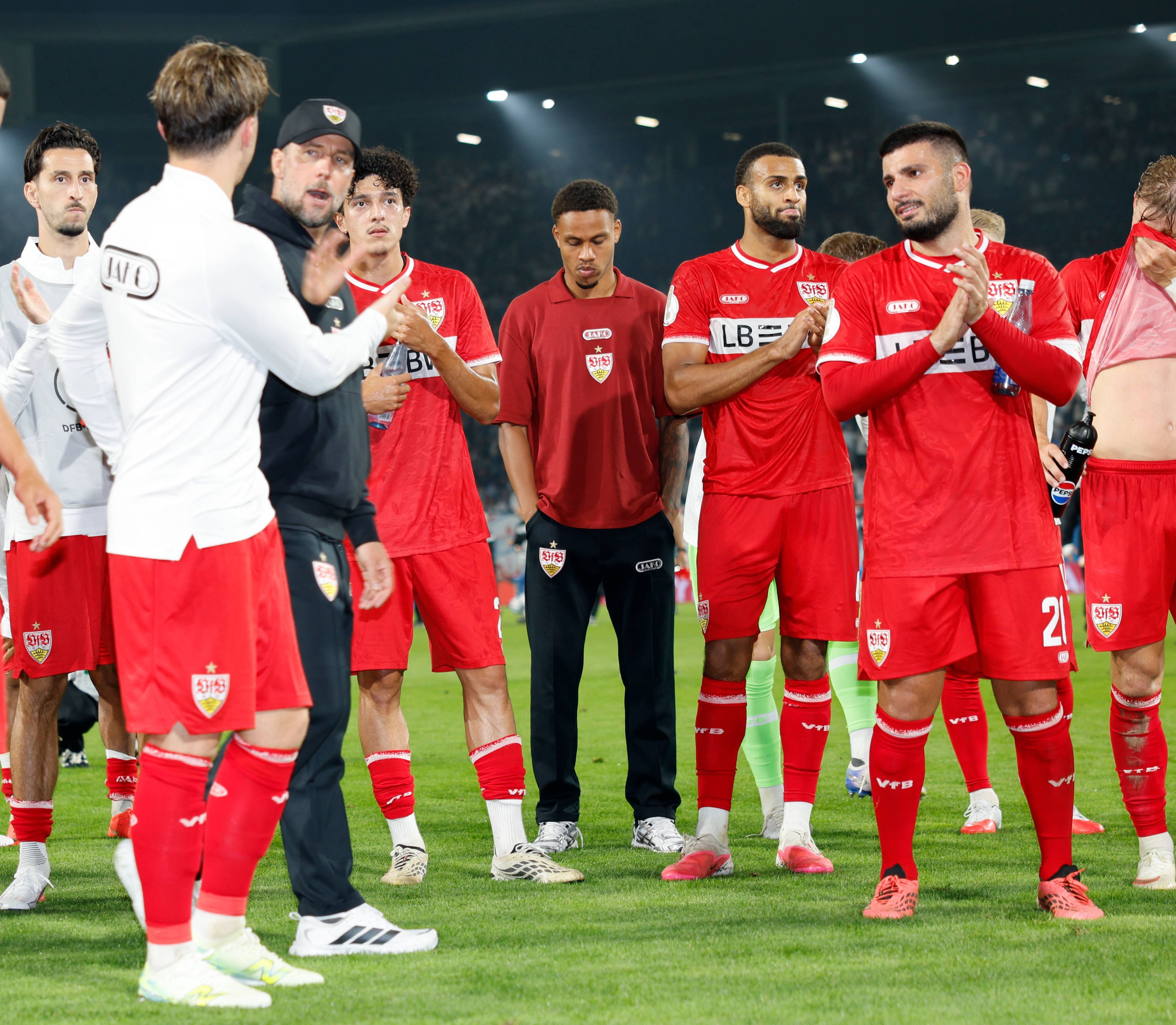 Die Stuttgart-Spieler feiern vor der Kurve, in der Mitte steht Nikolas Nartey mit gesenktem Kopf.
