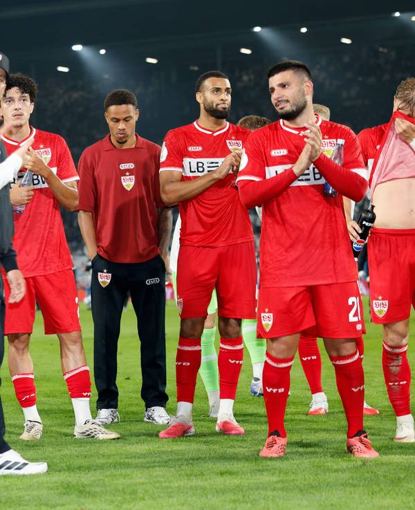 Die Stuttgart-Spieler feiern vor der Kurve, in der Mitte steht Nikolas Nartey mit gesenktem Kopf.