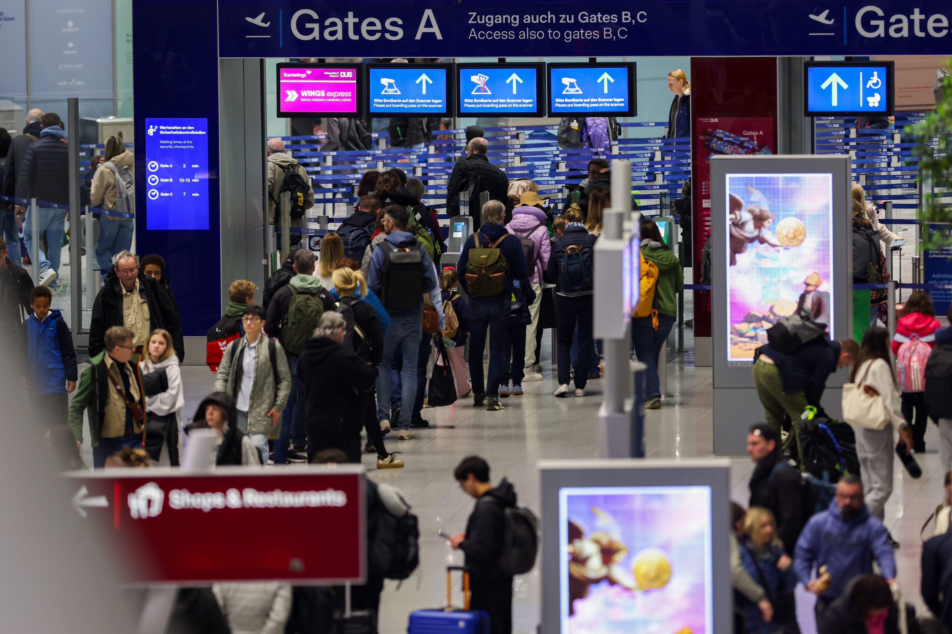 Reisende gehen in Richtung der Gates am Flughafen in Düsseldorf (Archivfoto).