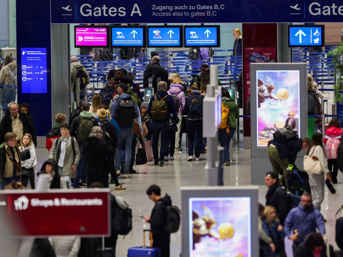 Reisende gehen in Richtung der Gates am Flughafen in Düsseldorf (Archivfoto).