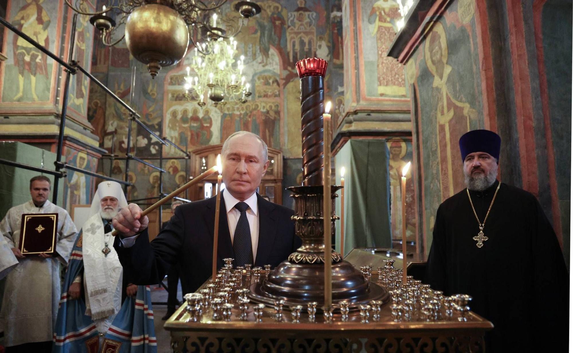 Putin zündet eine Kerze in der Moskauer Erzengelkatedrale an. Der Präsident lässt Reliquien eines „Kriegsheiligen“ ins Frontgebiet bringen.