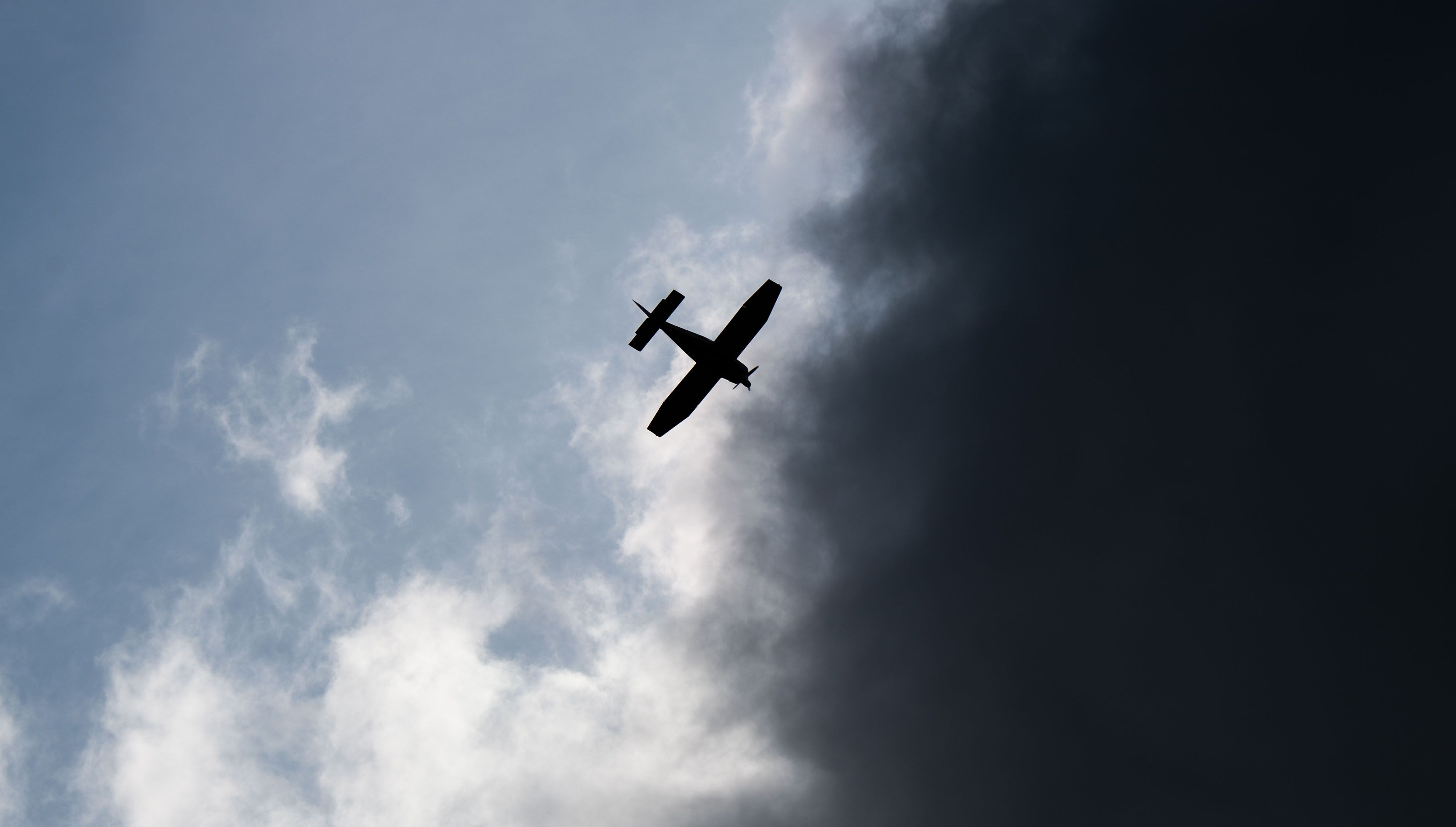 Ein Kleinflugzeug fliegt vor dunklen Wolken (Symbolfoto).