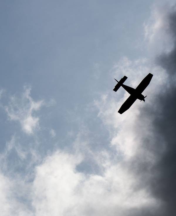 Ein Kleinflugzeug fliegt vor dunklen Wolken (Symbolfoto).