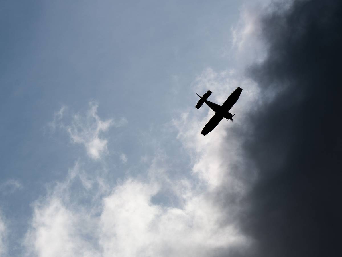 Ein Kleinflugzeug fliegt vor dunklen Wolken (Symbolfoto).