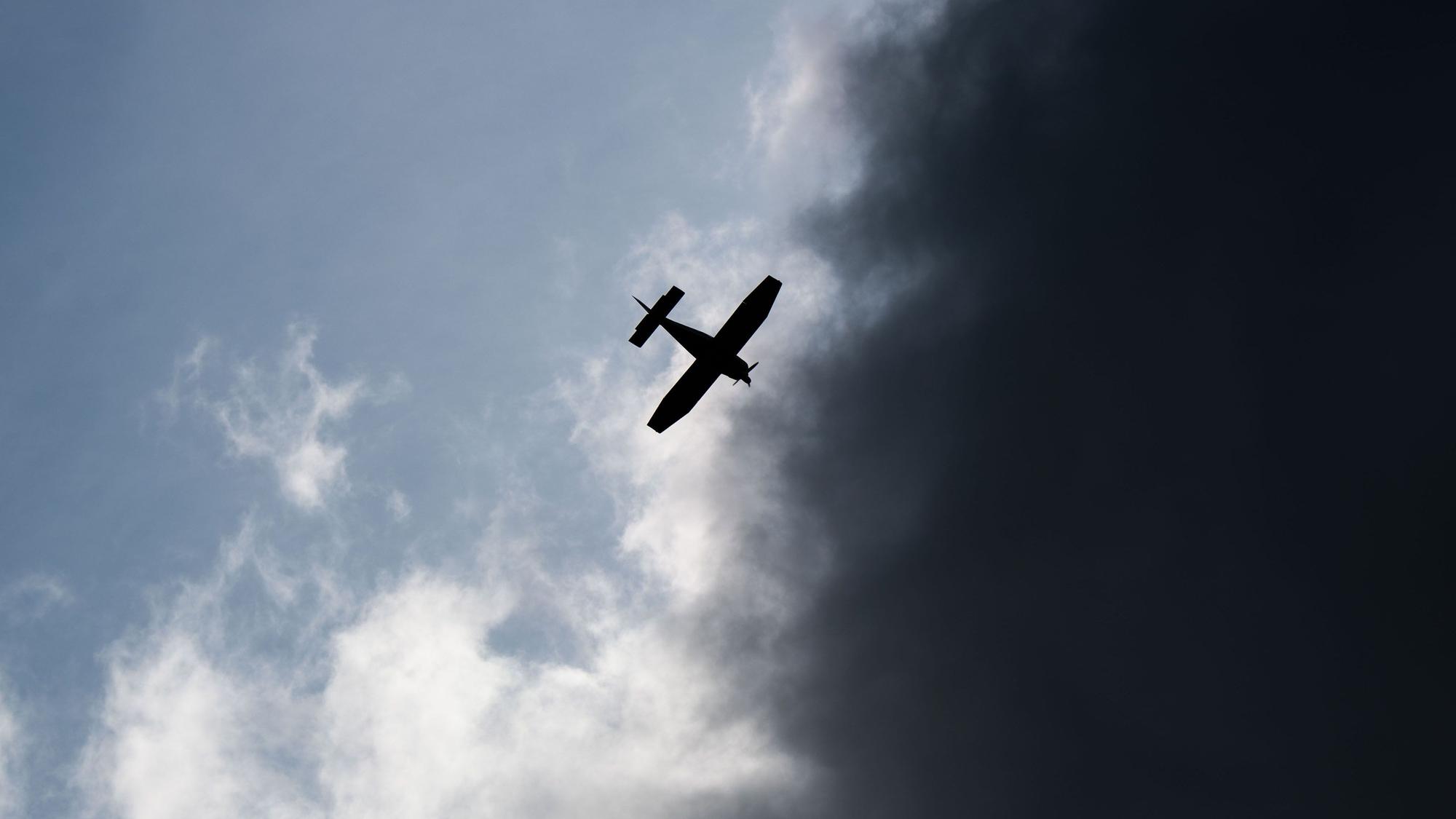 Ein Kleinflugzeug fliegt vor dunklen Wolken (Symbolfoto).