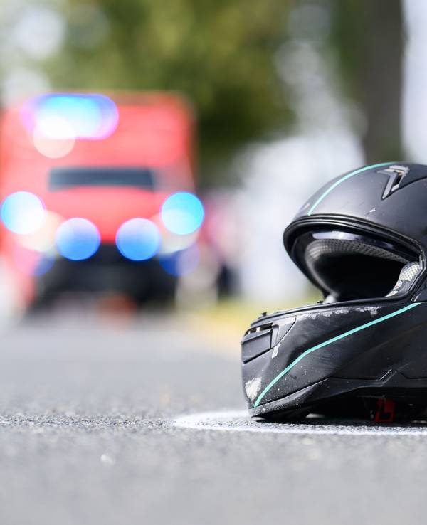 Der Helm eines Motorradfahrers liegt nach einem Unfall auf der Straße.