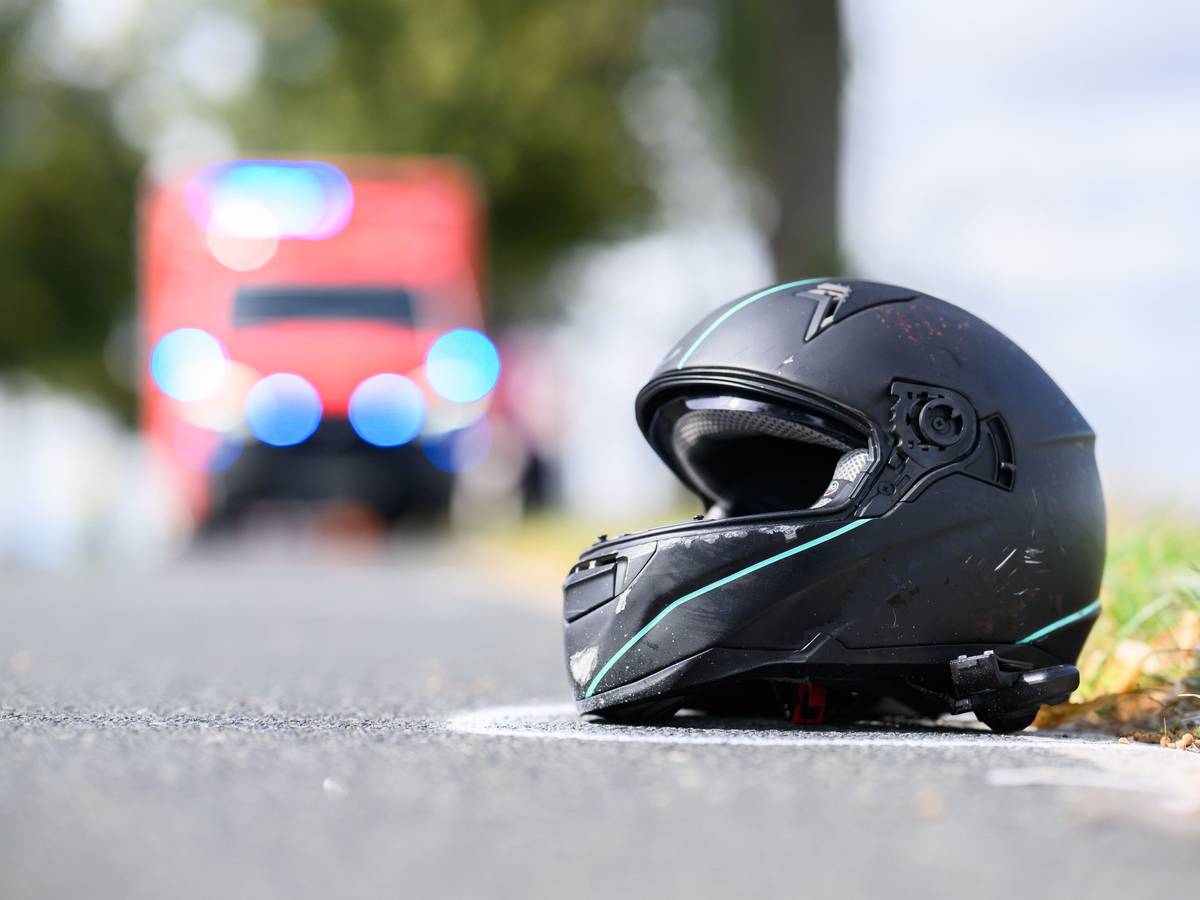 Der Helm eines Motorradfahrers liegt nach einem Unfall auf der Straße.