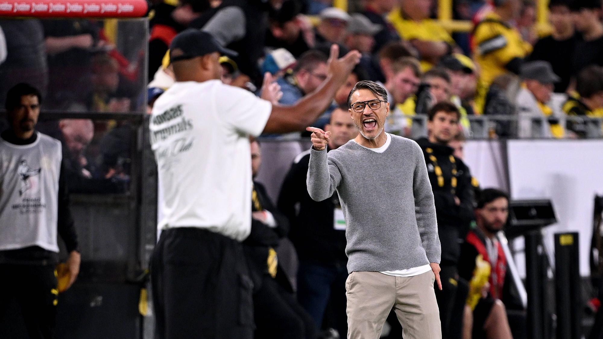 BVB-Trainer Niko Kovac zeigt wütend in Richtung der Trainerbank des FC Bayern. Bayern-Coach Vincent Kompany gibt derweil seinen Spielern Anweisungen.