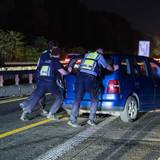 Auf einem Polizeifahrzeug warnt eine Leuchtschrift vor einer Unfallstelle.
