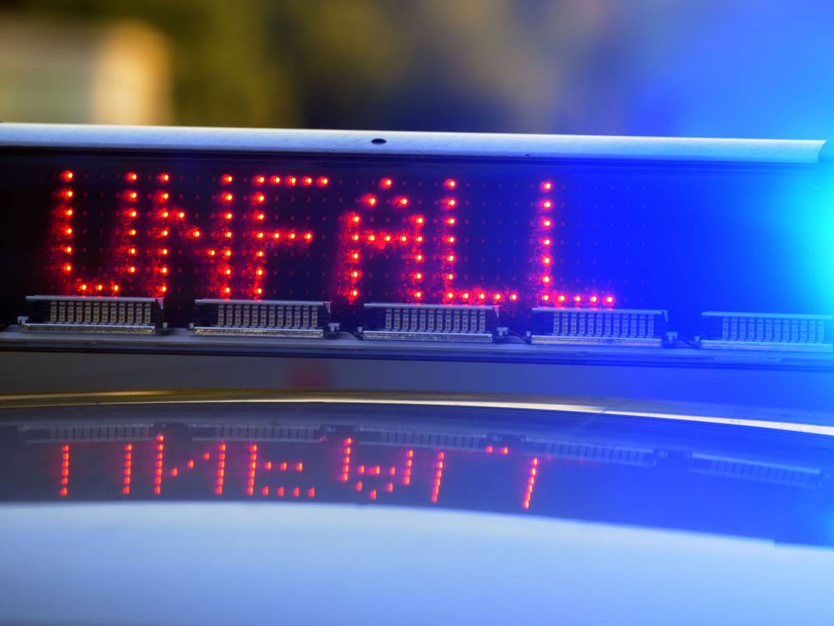 Auf einem Polizeifahrzeug warnt eine Leuchtschrift vor einer Unfallstelle.
