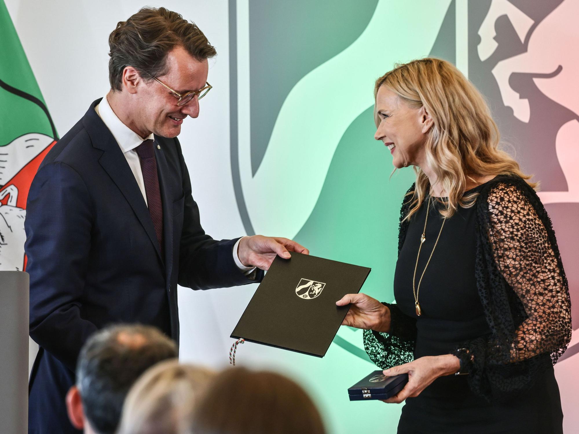 Veronica Ferres nimmt von Hendrik Wüst den Landesverdienstorden entgegen.