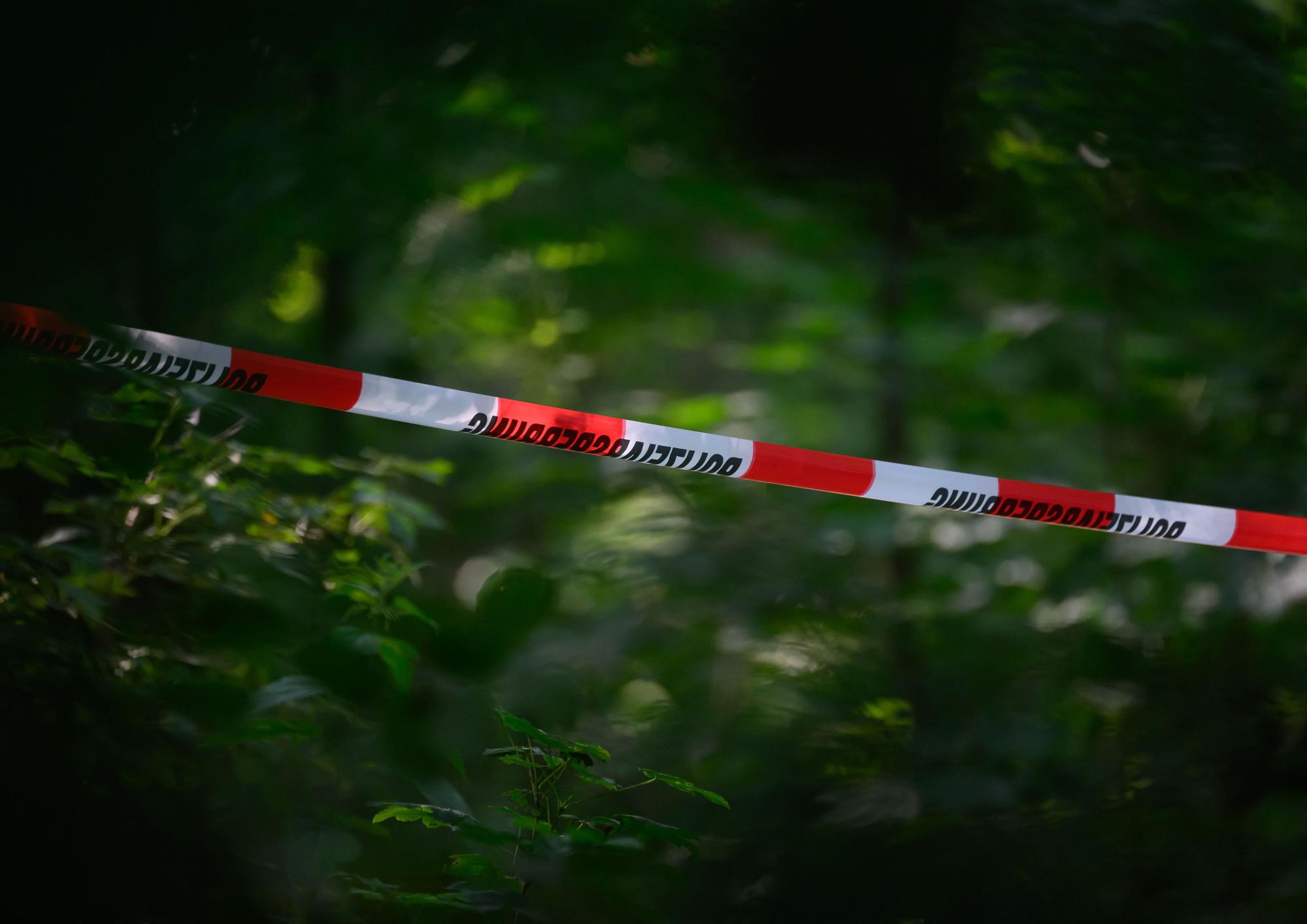 Absperrband der Polizei ist in einem Wald gespannt. (Symbolfoto)
