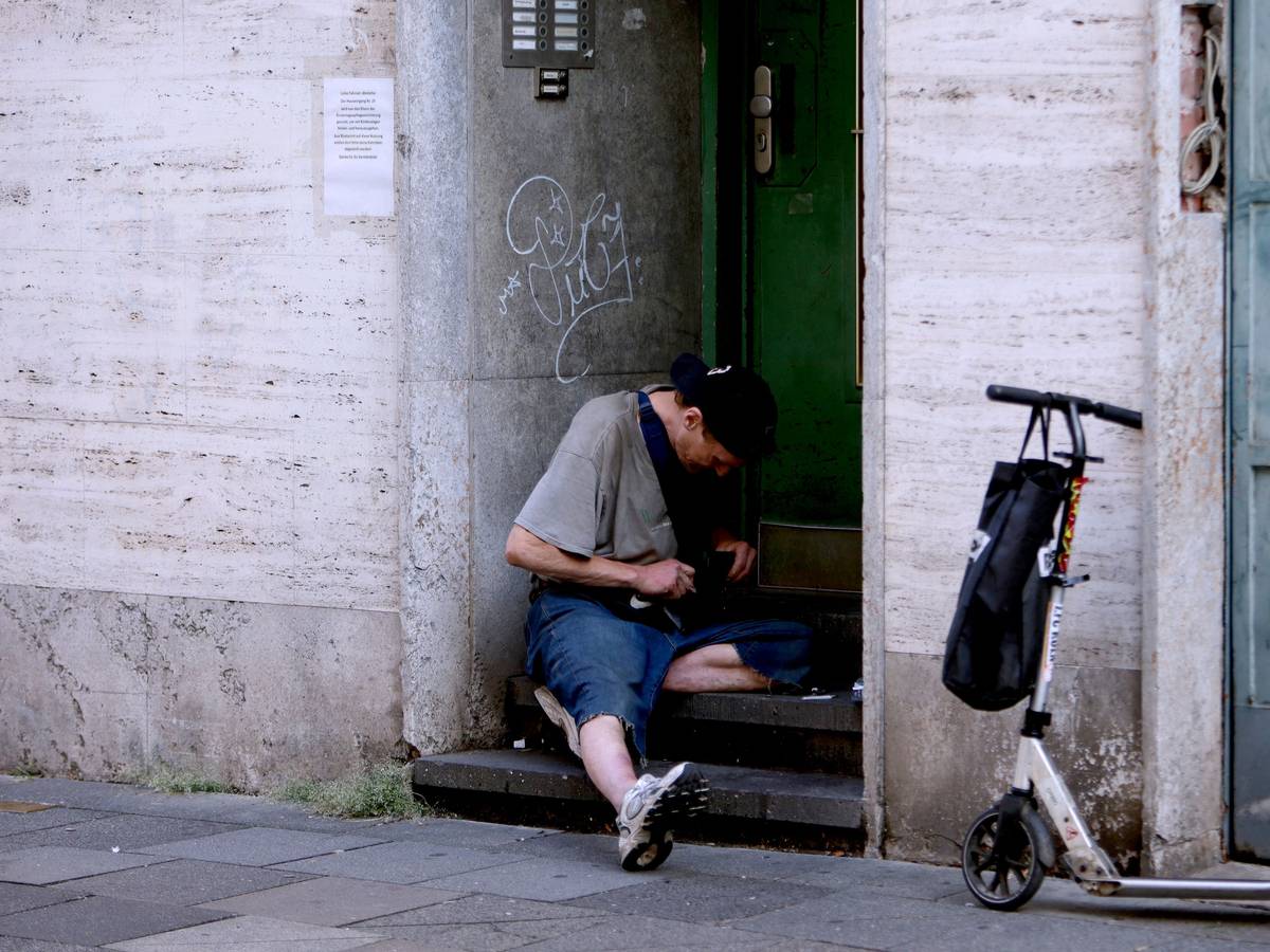 Ein Junkie setzt sich am Hauseingang einen Schuß.