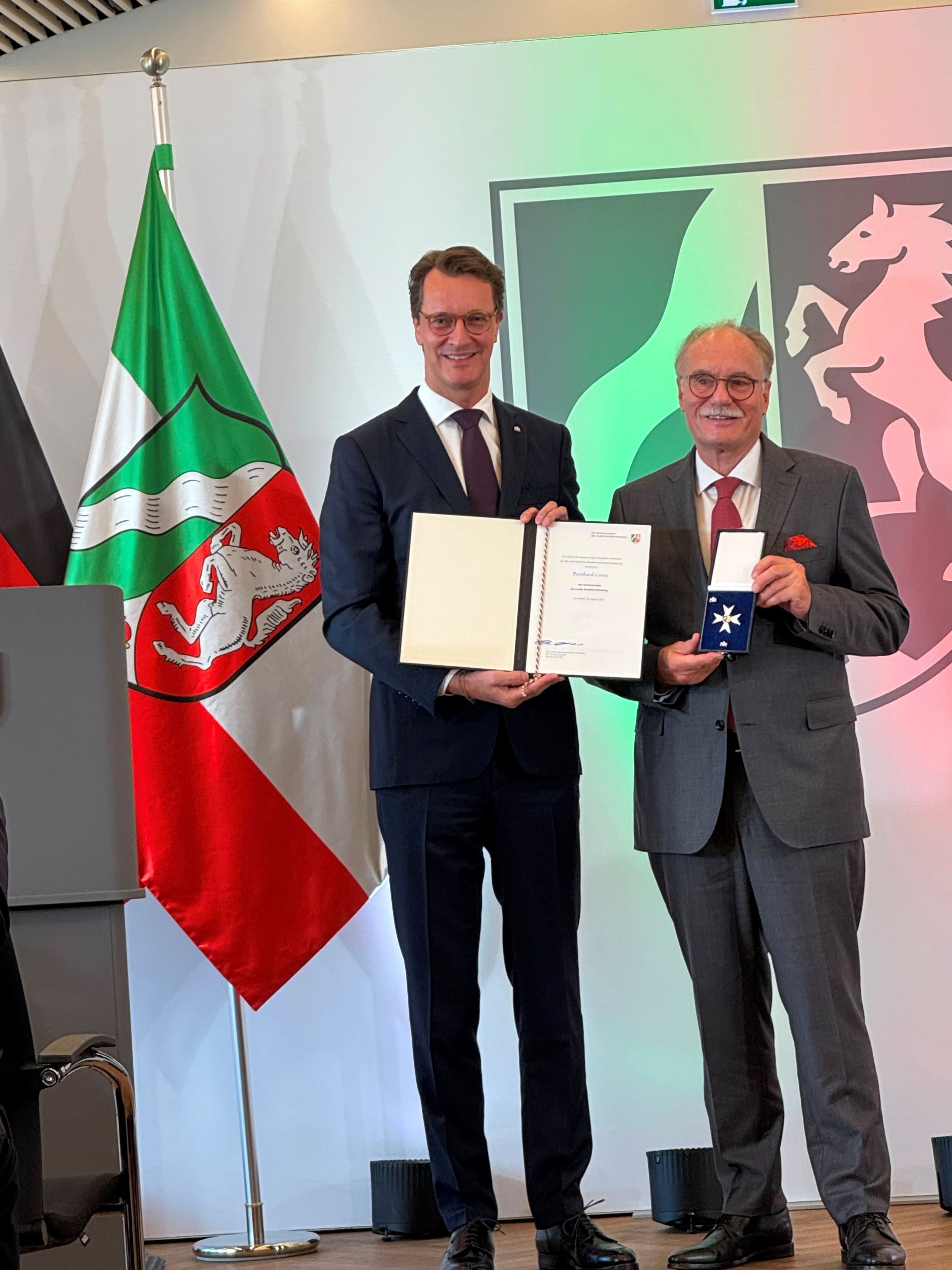 Hendrik Wüst überreicht den Verdienstorden an Bernhard Conin.