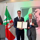 Hendrik Wüst überreicht den Verdienstorden an Bernhard Conin.