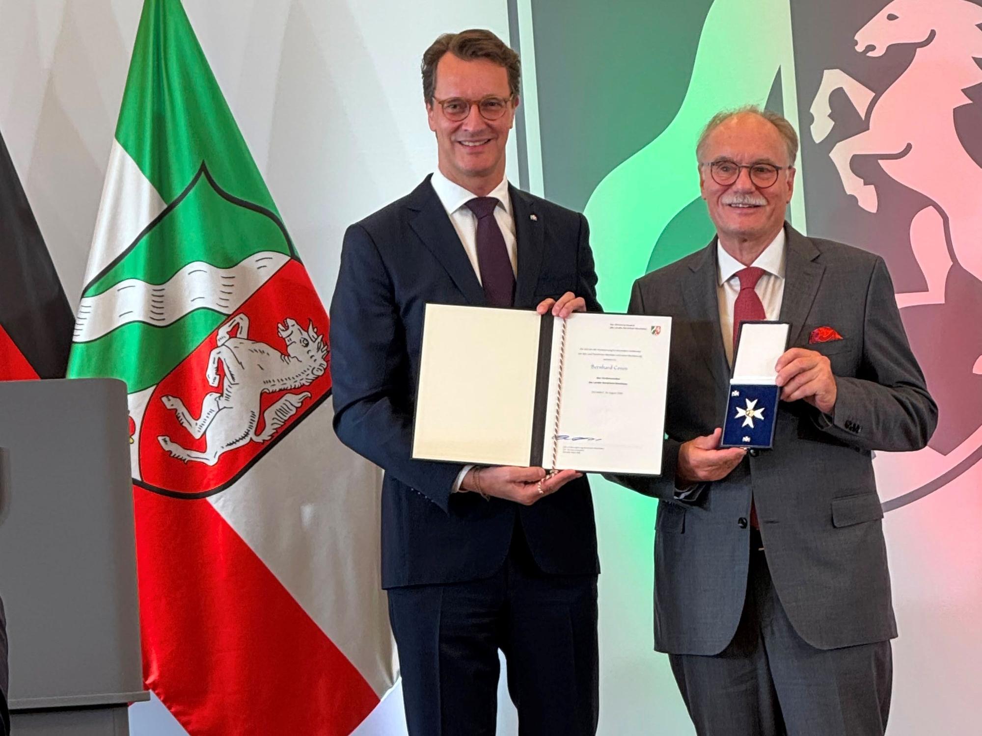 Hendrik Wüst überreicht den Verdienstorden an Bernhard Conin.