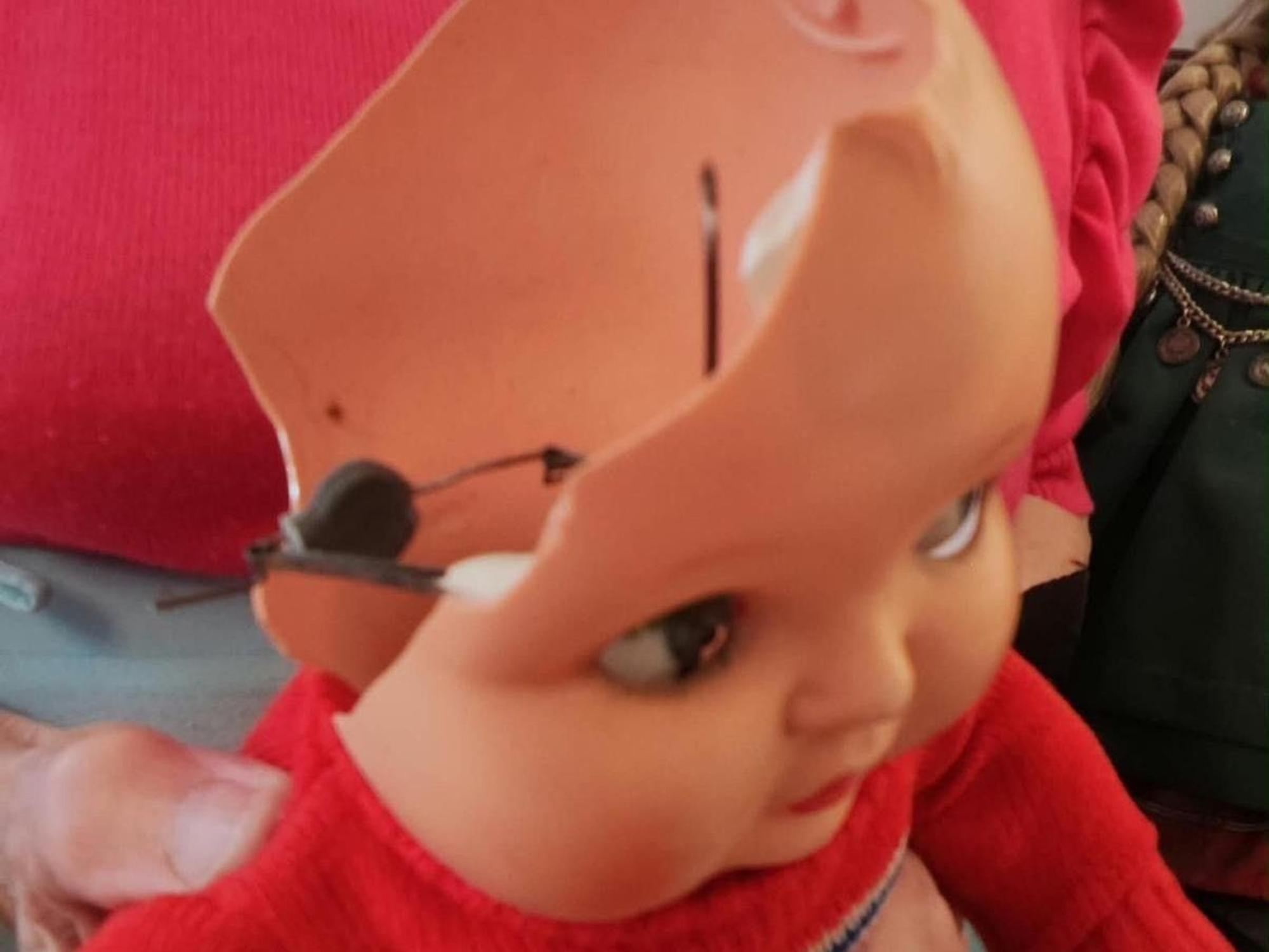 Der Puppe fehlt die Hälfte des Kopfes.