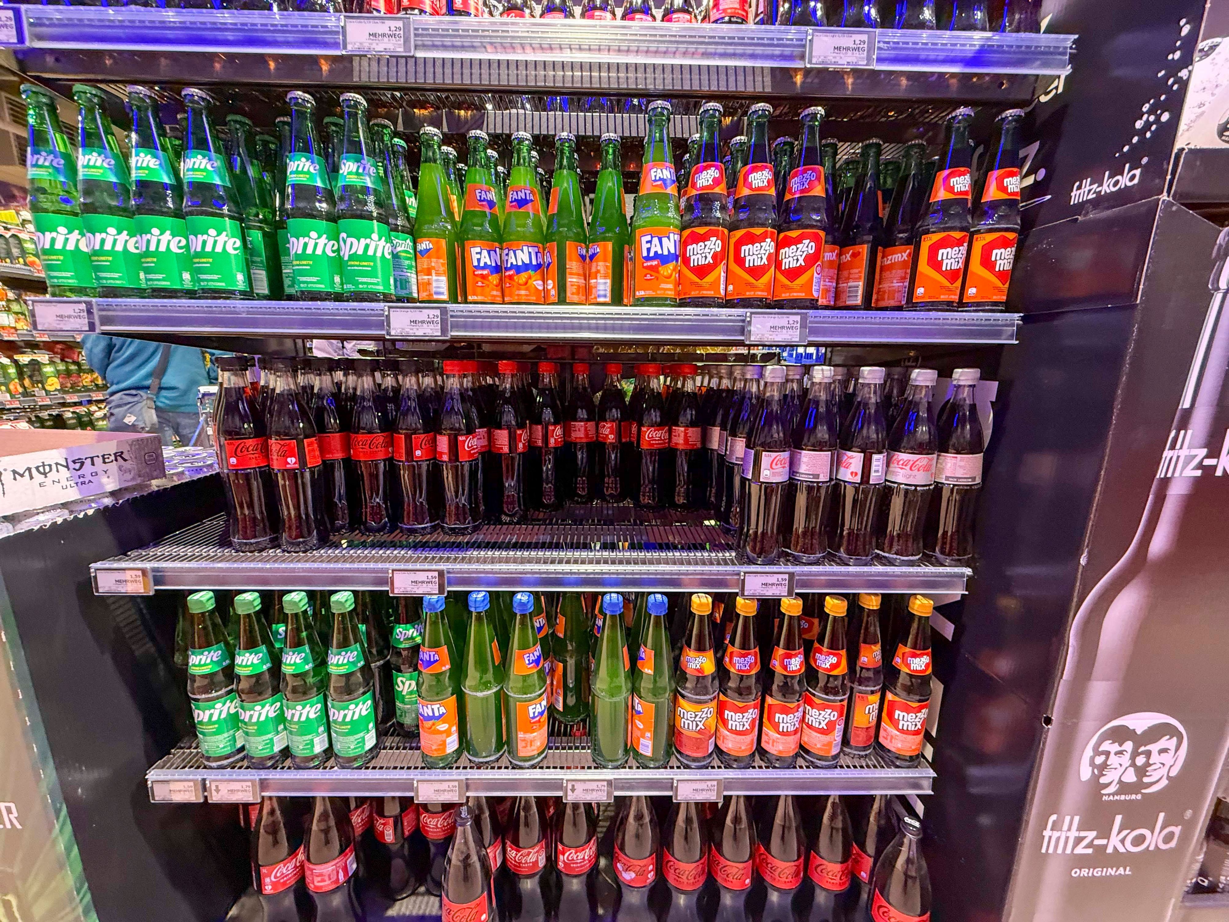 Regal mit Coca Cola Sprite Fanta Plastik Einwegflaschen im Getraenkemarkt.