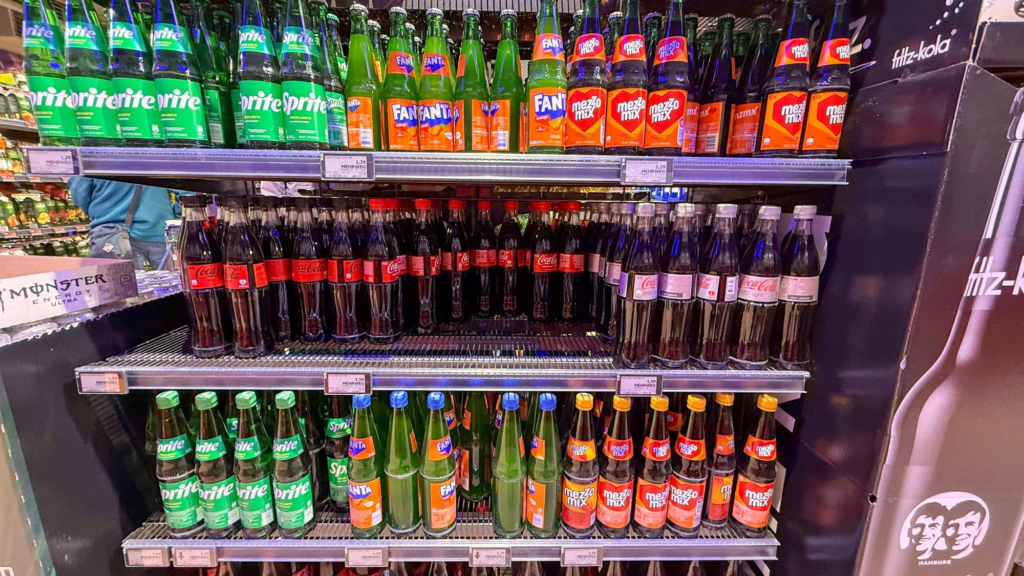 Regal mit Coca Cola Sprite Fanta Plastik Einwegflaschen im Getraenkemarkt.