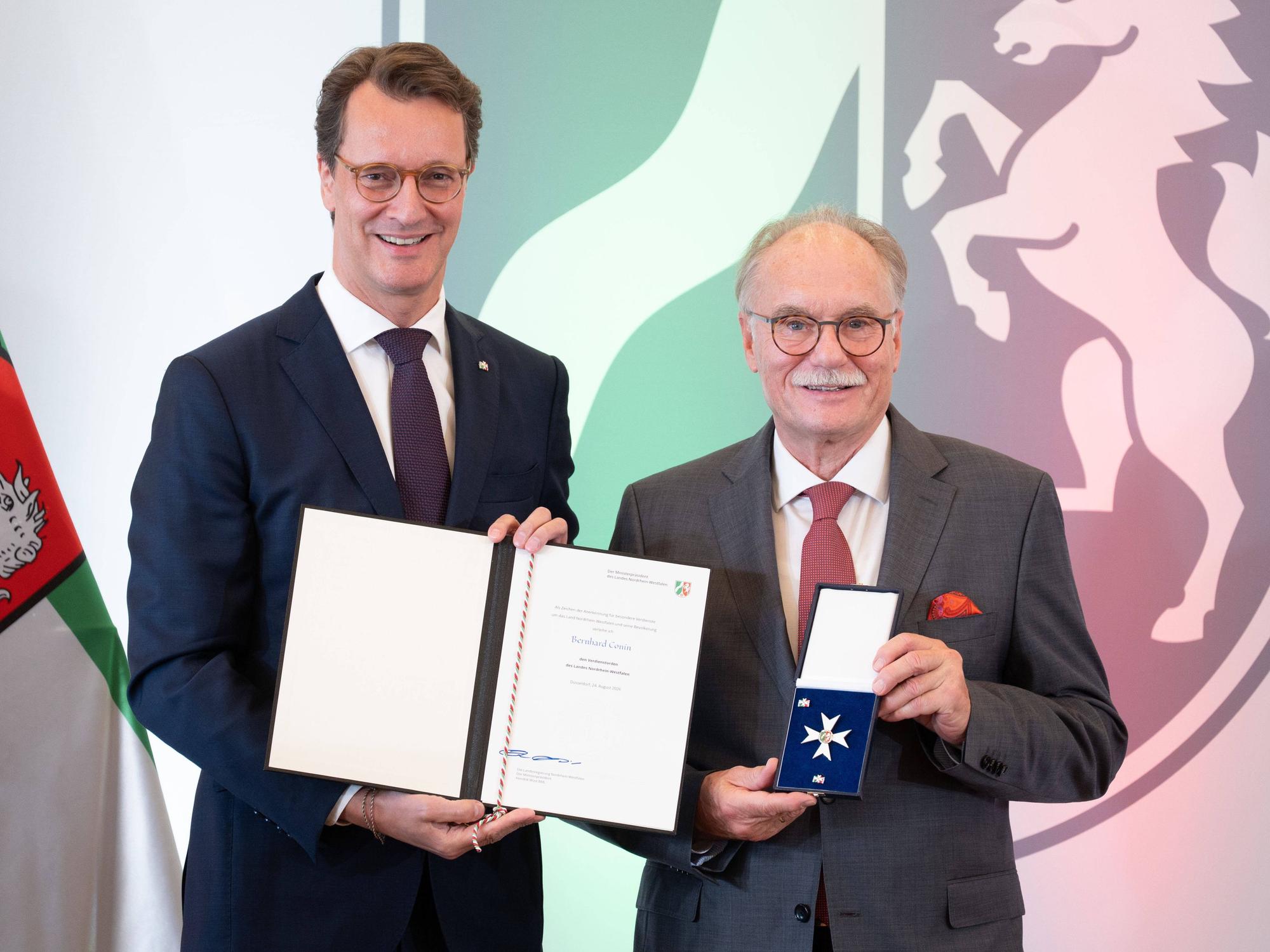 Bernhard Conin wird von Hendrik Wüst ausgezeichnet.