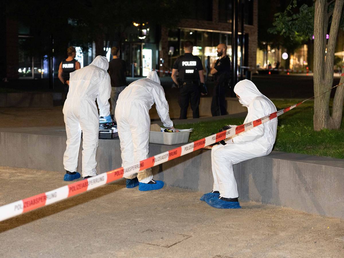 Drei Personen in Schutzanzügen sind an einem Tatort im Einsatz.