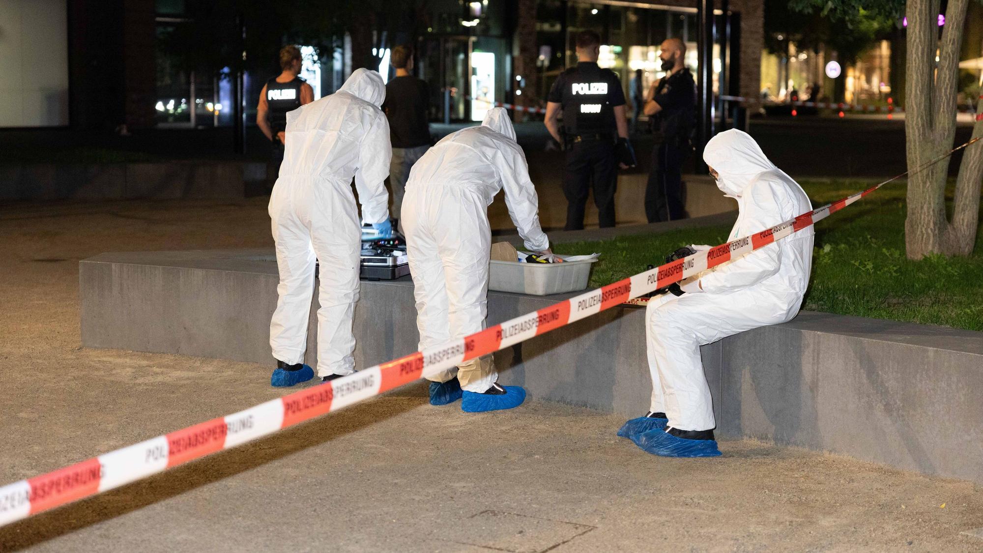 Drei Personen in Schutzanzügen sind an einem Tatort im Einsatz.